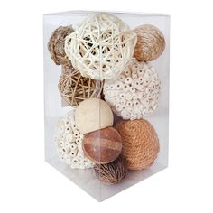 a clear box filled with lots of different types of balls and seashells on top of each other