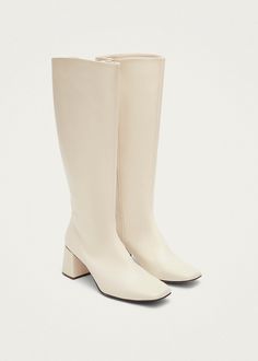 White vegan knee-high boots with heels Chalk is a vegan boot crafted from faux leather with a polished white finish. Coming in a knee-high, it features a chunky block heel and slim, squared toes. Plus, full-length zippers on the side ensure they slip on and off with ease. Boots With Heels, White Leather Boots, Vegan Leather Boots, Vegan Boots, Chunky Block Heels, White Boots, Laos, Ghana, Knee High Boots