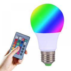 a person holding a remote control next to a colorful light bulb