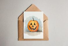 a card with a watercolor painting of a pumpkin