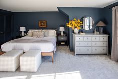 a bedroom with blue walls and white furniture