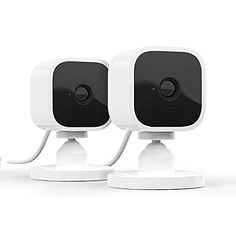 three white security cameras sitting next to each other on top of a white surface,