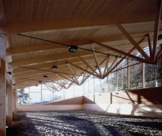 the inside of a building with wooden beams and windows on each side, along with carpeted flooring