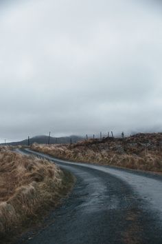 an empty road in the middle of nowhere on a foggy day with no cars