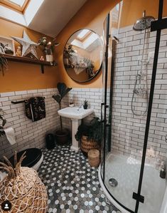 a bathroom with orange walls and black and white tile flooring is pictured in this image