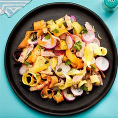 a black plate filled with food on top of a blue table