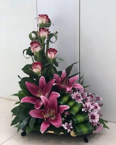 a bouquet of pink flowers sitting on top of a wooden table next to a white wall