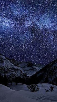 the night sky is filled with stars above snowy mountains