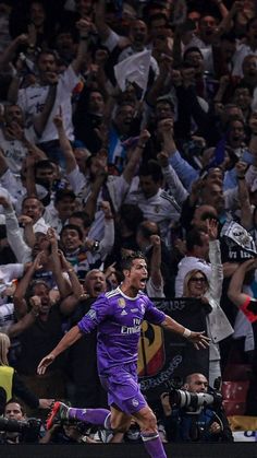 the soccer player is celebrating his goal in front of an excited crowd as he runs towards the camera