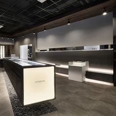 the interior of a modern store with black and white counter tops, lighting up the room