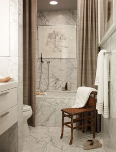 a white bathroom with marble walls and floor