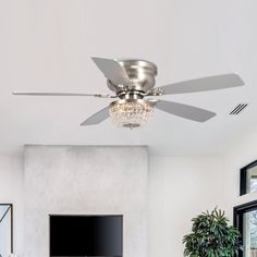 a living room with a ceiling fan and a flat screen tv mounted on the wall