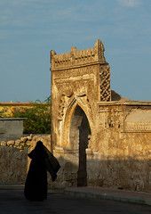 a woman walking down the street in front of an old building