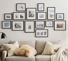 a living room filled with furniture and lots of framed pictures on the wall above it