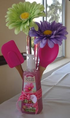 a vase filled with flowers sitting on top of a table next to scissors and other items