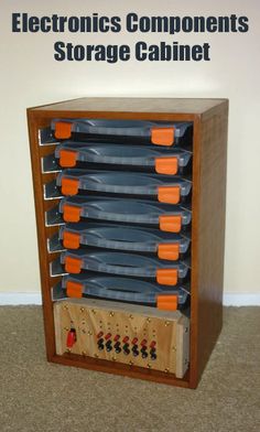 a wooden cabinet with many plastic plates and cups on the bottom shelf, in front of a white wall