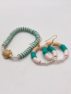 three bracelets with beads and shells on them