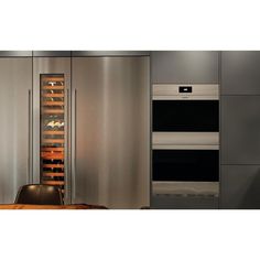 a kitchen with stainless steel appliances and an oven in the corner, next to a dining room table