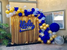 the balloon arch is decorated with blue, gold and white balloons that read wela