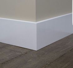 the corner of an empty room with wood flooring