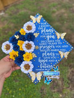 someone holding up a blue graduation cap with flowers on it that says i know the plans