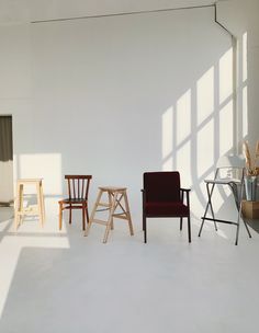 three chairs are lined up against the wall in an empty room with sunlight coming through the windows