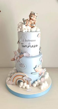 a three tiered cake with clouds and animals on it