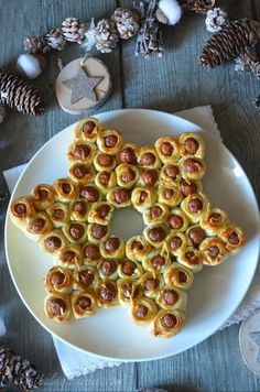 a white plate topped with pastries on top of a wooden table next to pine cones