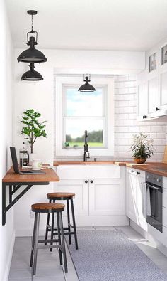 a kitchen with two stools in front of a window and a potted plant on the counter