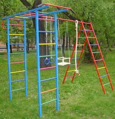 a swing set with swings and ladders in the grass