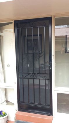 a black iron door on the side of a house