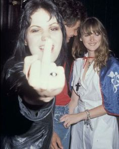 two women pointing at the camera while another woman looks on