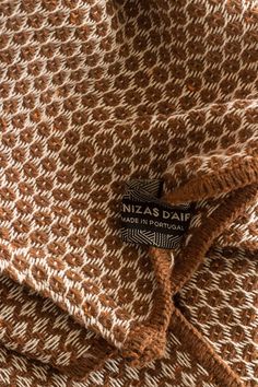 a brown and white blanket with a label on it