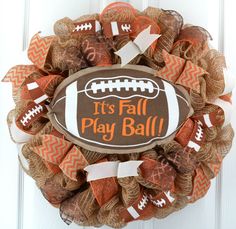 a football wreath with the words it's fall play ball on it and some burl