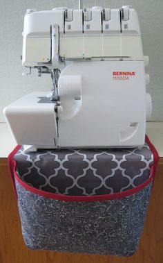 a sewing machine sitting on top of a table next to a red and white container