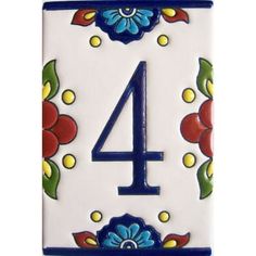 the number four is decorated with blue and red flowers on a white tile wall or floor