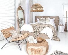 a bed room with a neatly made bed and some pillows on the floor next to a chair