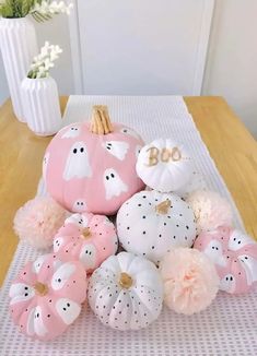 pink and white pumpkins are arranged on a table