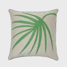 a green and white pillow with palm leaf print on it's front, sitting on a gray background