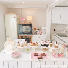 a kitchen counter topped with lots of cupcakes and cakes