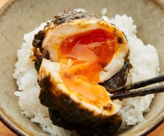 an egg shell with rice and chopsticks in a bowl