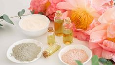 the ingredients for making homemade face scrubs sit on a table next to pink flowers