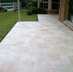 an outdoor patio with stone tiles and grass