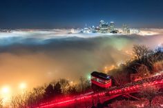 a train traveling through a foggy city at night