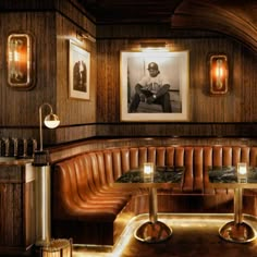 the interior of a restaurant with leather booths and pictures on the wall above it, along with candles