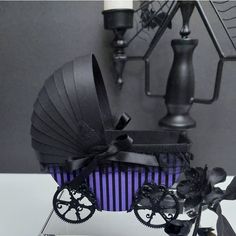 a black and purple buggy is sitting on a white table next to some candles