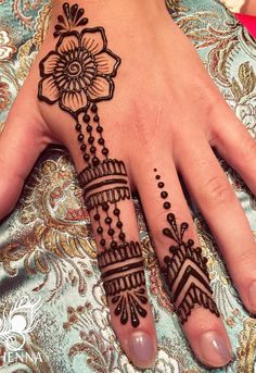 a woman's hand with henna tattoos on it