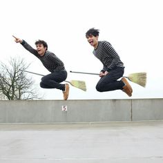 two men jumping in the air with brooms