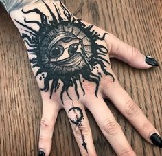 a person's hand with black ink on it and an eye in the middle