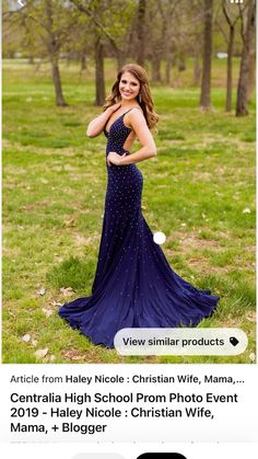 a beautiful woman in a long dress posing for a photo with her hands on her hips